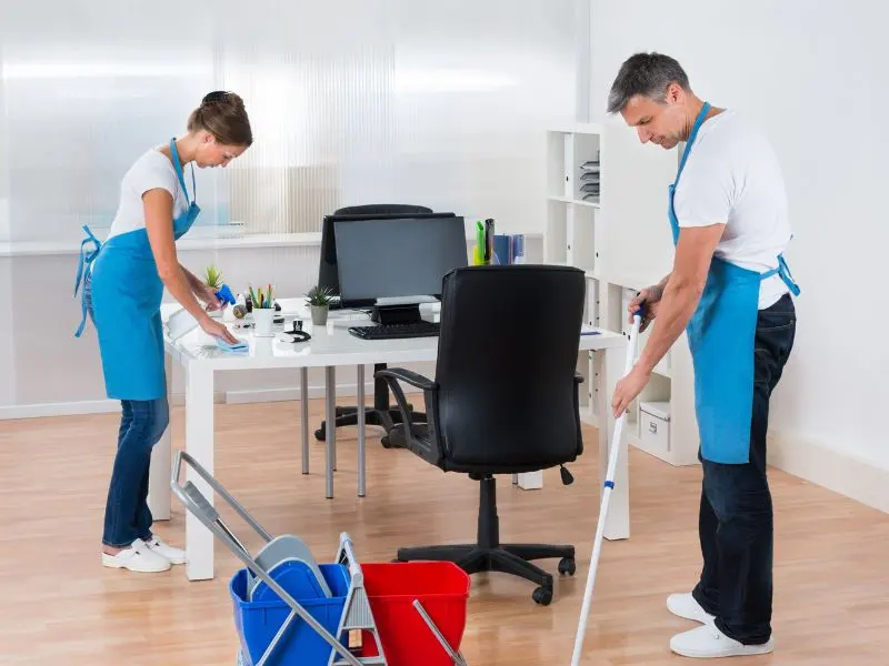 Professional cleaner mopping tiled floor of a restaurant restroom