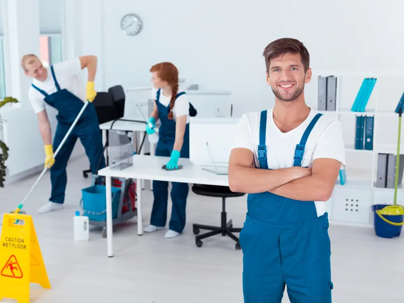 Cleaning team working together to tidy up an office space